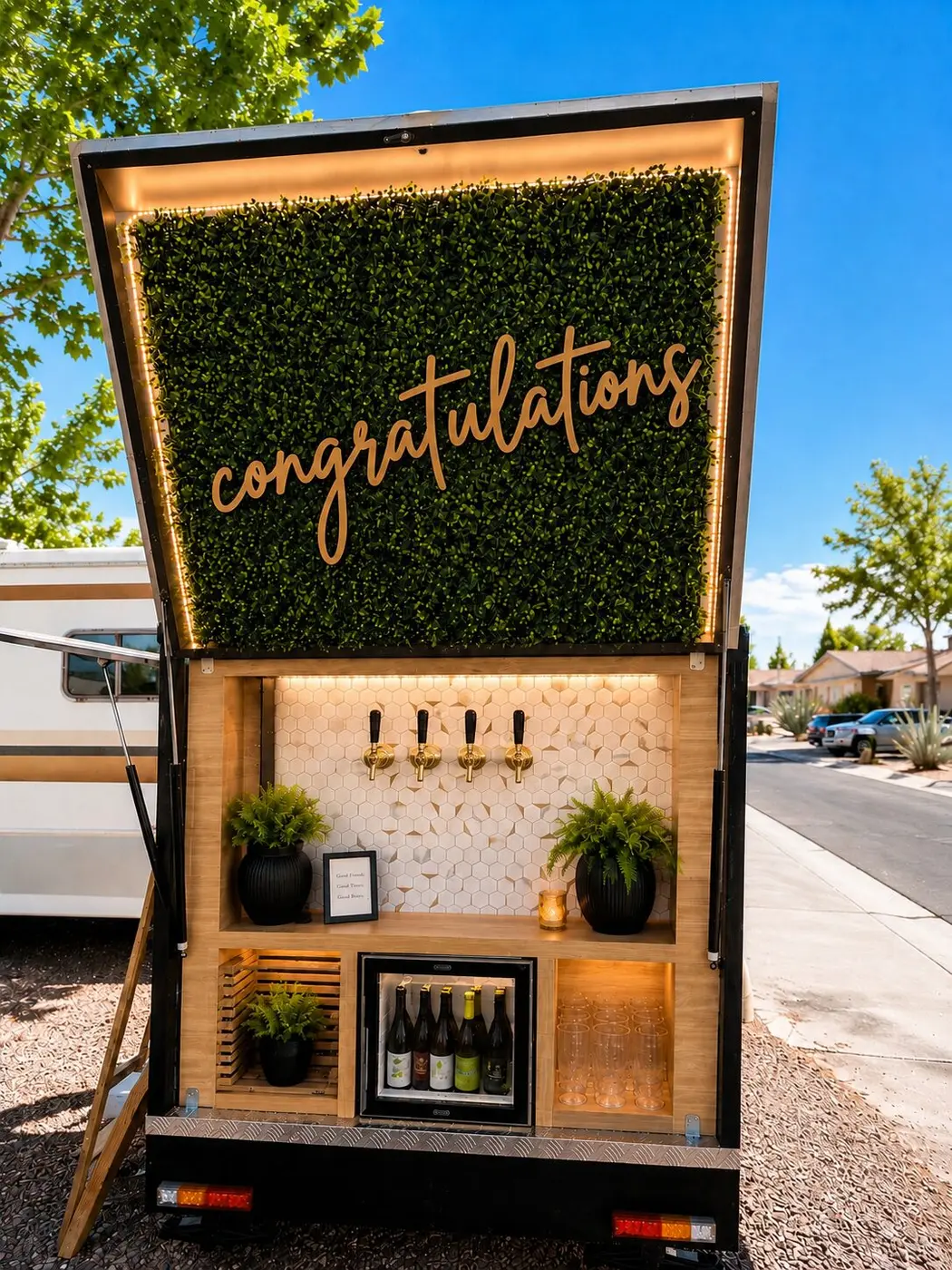 Lola, the mobile bar, open with greenery wall, taps and bottles
